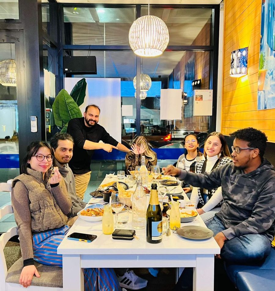 A group of friends laughing together over dinner at Zaafran